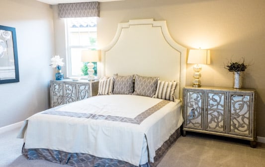 Luxurious master suite with elegant bed, mirrored nightstands, and soft lighting, showcasing a stylish home extension.