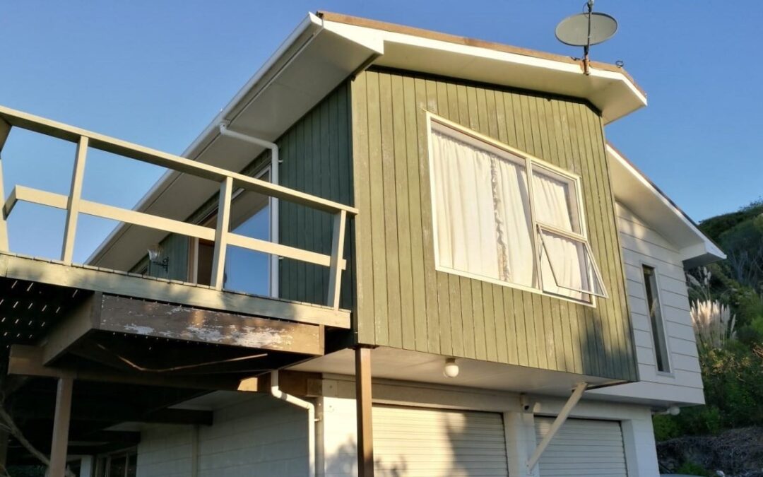House exterior with worn weatherboards and original windows, ideal for a quality window replacement and cladding upgrade.