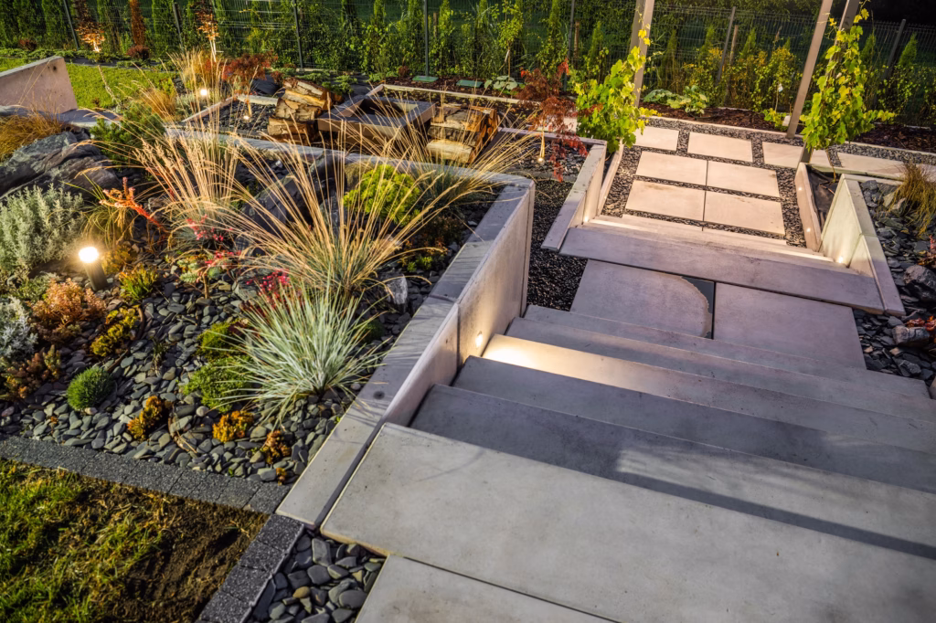 Modern tiered landscape garden with stone steps, paving, and integrated outdoor lighting, enhancing aesthetics.