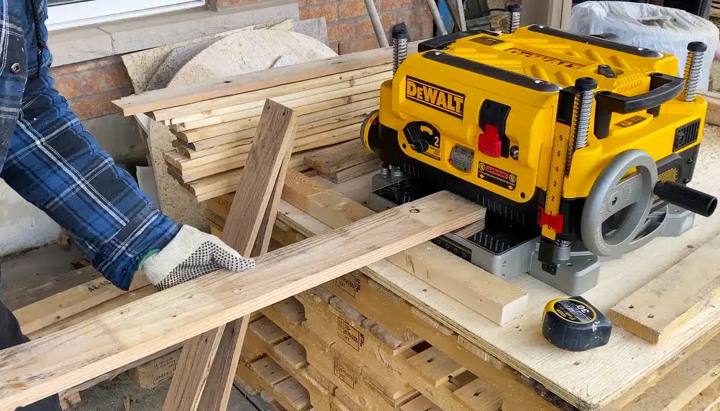 Worker feeding planks into a finishing machine
