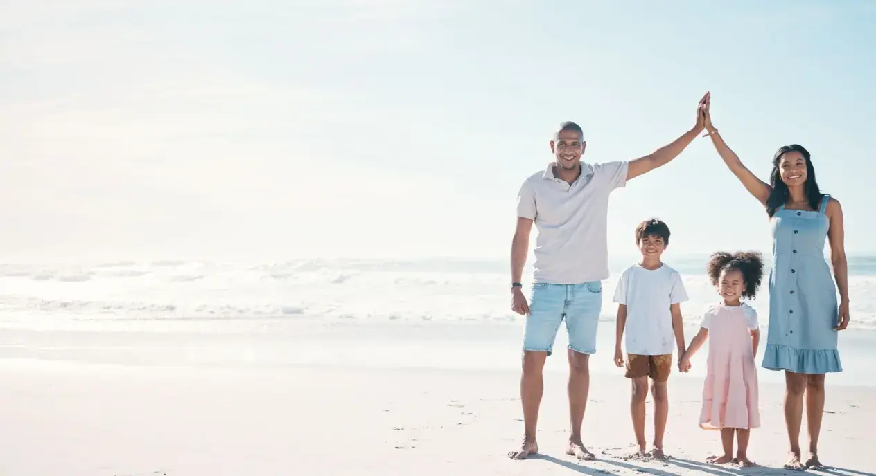 Family enjoying a sunny day on the Kapiti Coast beach, envisioning their future in a new home built by Smartway Builders